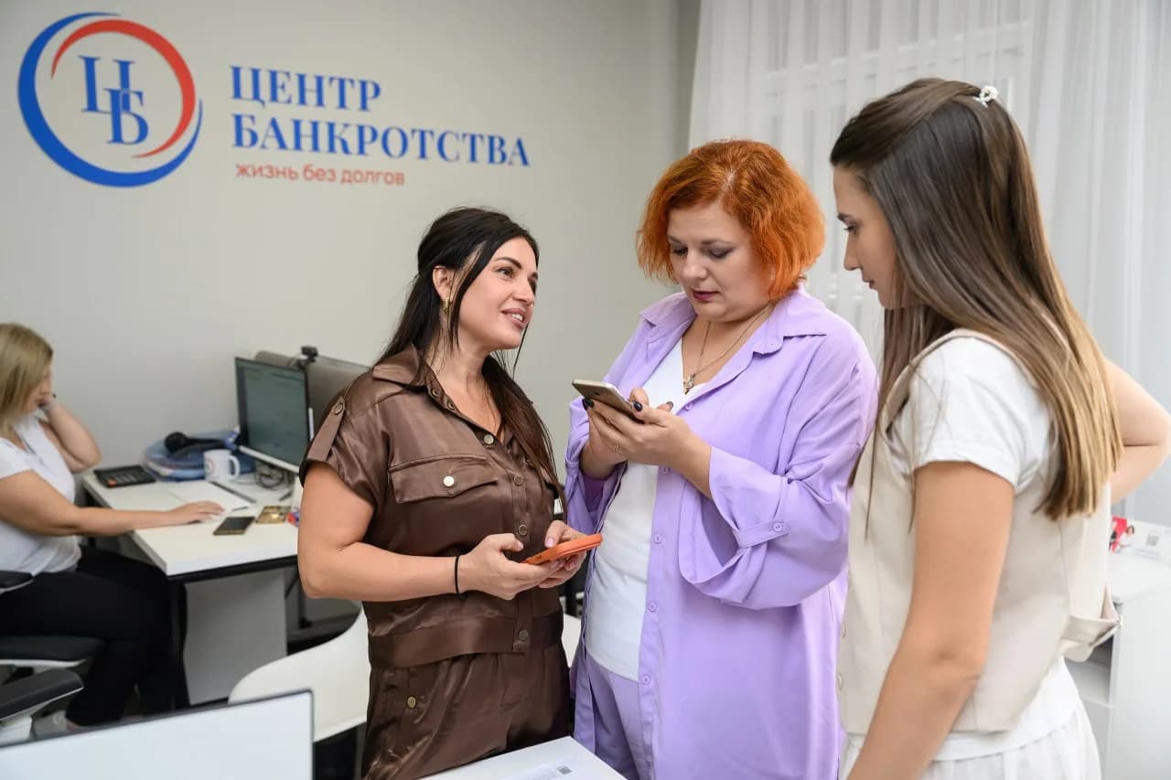 Сотрудники «Центра Банкротства» на приёме у стены с логотипом